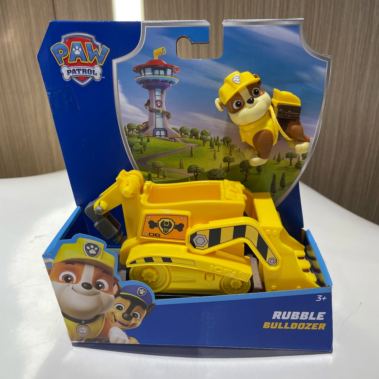 Jouet bulldozer jaune Pat Patrouille Rubble avec figurine chien, dans sa boîte.