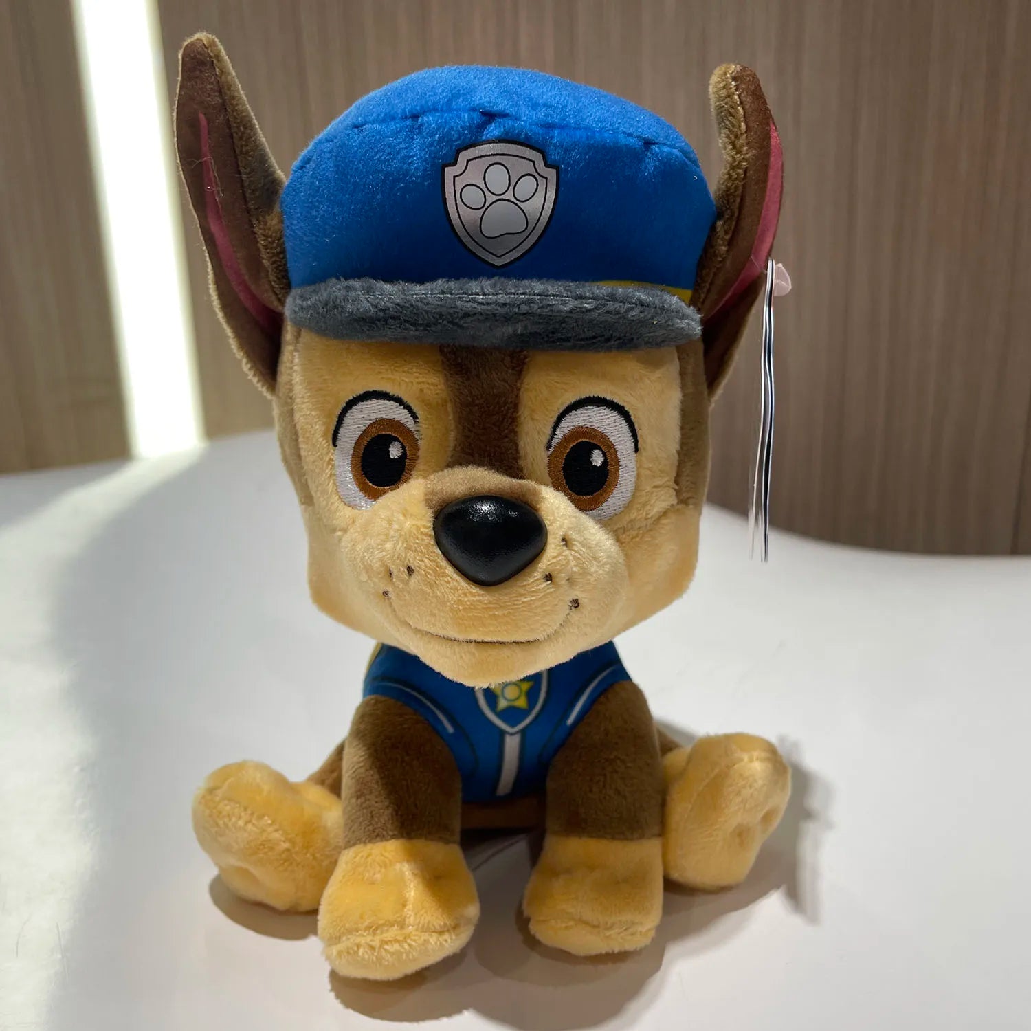 Peluche Pat Patrouille chien Chase, tête avec bonnet bleu et tablier bleu, pattes beiges
